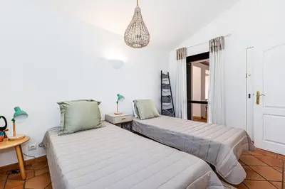 two beds in a room with white walls at Villa Falésia in Olhos de Água