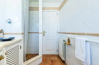 a bathroom with a shower and a white door at Villa Falésia in Olhos de Água