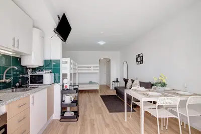 a kitchen and living room with a table and a couch at The Oura Stay in Albufeira