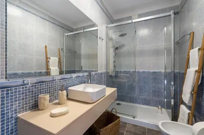 a blue tiled bathroom with a sink and a shower at Alma Invicta Albufeira in Albufeira