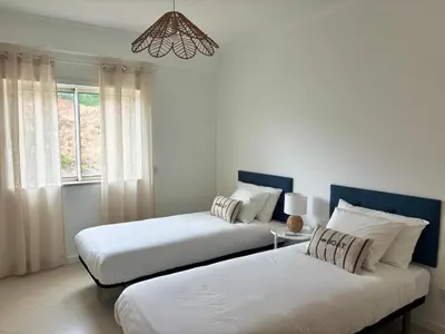 two beds in a room with a window at SummerSalt Apartment - Albufeira Old Town in Albufeira
