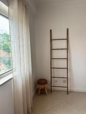 a room with a ladder and a stool next to a window at SummerSalt Apartment - Albufeira Old Town in Albufeira