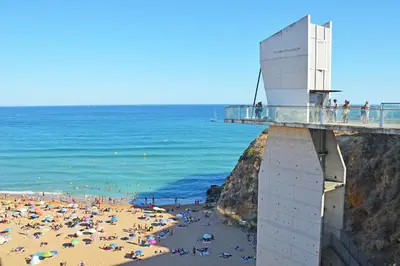 a bridge over a beach with a crowd of people at SummerSalt Apartment - Albufeira Old Town in Albufeira