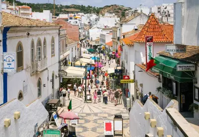 a group of people walking down a city street at SummerSalt Apartment - Albufeira Old Town in Albufeira