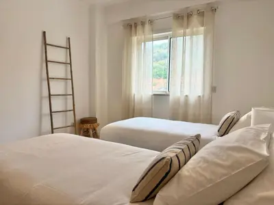two beds in a room with a window and a ladder at SummerSalt Apartment - Albufeira Old Town in Albufeira