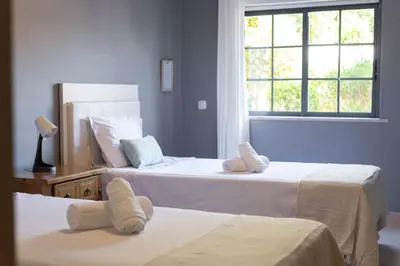 two beds in a room with a window at Modern 2BR Quarteira Apartment in Quarteira