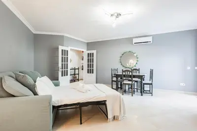 a living room with a couch and a table at Modern 2BR Quarteira Apartment in Quarteira