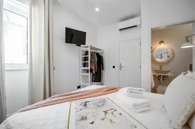 a white bedroom with a bed with towels on it at Urban Bliss Boutique Guesthouse in Faro
