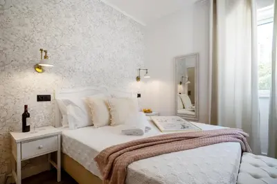a white bedroom with a bed and a mirror at Urban Bliss Boutique Guesthouse in Faro