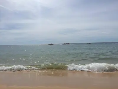 a beach with two ships in the ocean at Pátio da Várzea in Albufeira