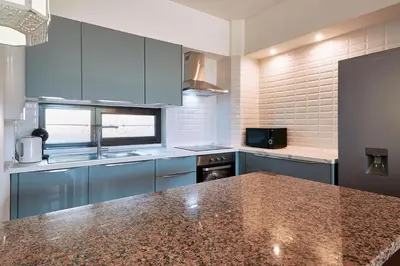 a kitchen with blue cabinets and a counter top at Apartment Green Oasis in Albufeira Jardim mit Pool in Albufeira