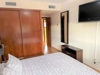 a bedroom with a bed and a wooden door at Villa Filó , Vila Sol with pool in Quarteira