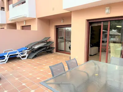 a pink house with a stone wall at Villa Filó , Vila Sol with pool in Quarteira