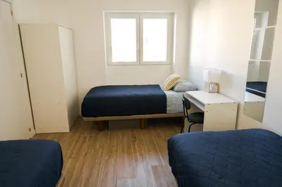 a small room with two beds and a window at Casas Sao Luis in Faro