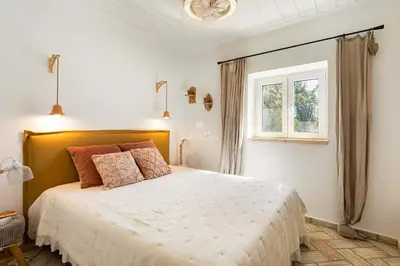 a bedroom with a large white bed with a window at Casa Bela Mar in Albufeira