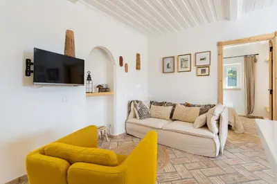 a living room with a couch and two chairs at Casa Bela Mar in Albufeira