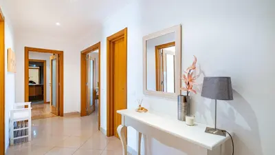 a white room with a table and a mirror at Falesia Marina in Quarteira