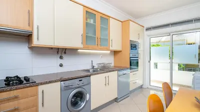 a kitchen with white cabinets and a dishwasher at Falesia Marina in Quarteira