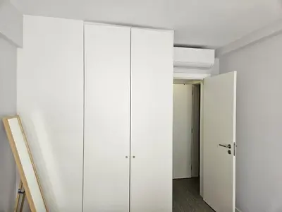 a room with white cabinets and a hallway at Quarteira flat AC balcony and view in Quarteira