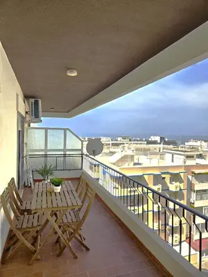 a balcony with two chairs and a table at Quarteira flat AC balcony and view in Quarteira