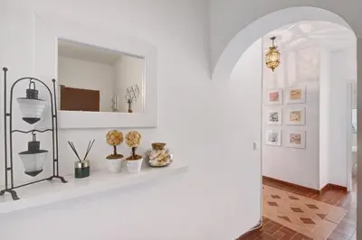 a hallway with white walls and a shelf with plants at Apartamento Mar Azul - Quarteira in Quarteira