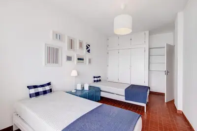 a bedroom with two beds and a white cabinet at Apartamento Mar Azul - Quarteira in Quarteira