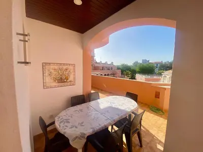 a table and chairs in a room with a balcony at Vila Lusa Marina in Vilamoura