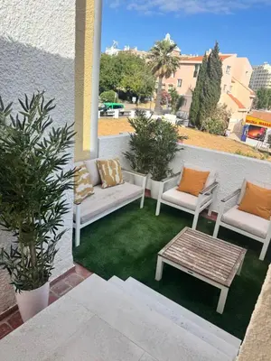 a patio with two couches and a table on grass at FM Marina Vilamoura in Quarteira