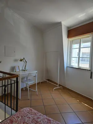 a bedroom with a desk and a table and a window at Casa Alfazema in Faro