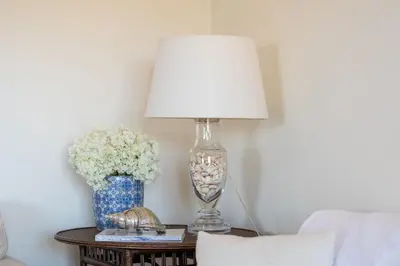 a lamp on a table next to a vase of flowers at Penthouse with Pool View in Albufeira by Lovelystay in Albufeira