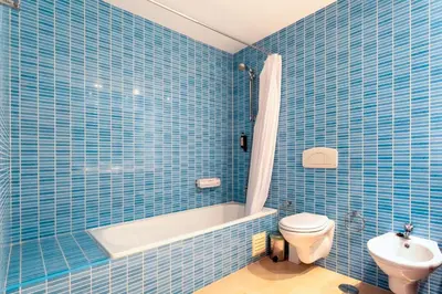 a blue tiled bathroom with a toilet and a sink at Penthouse with Pool View in Albufeira by Lovelystay in Albufeira