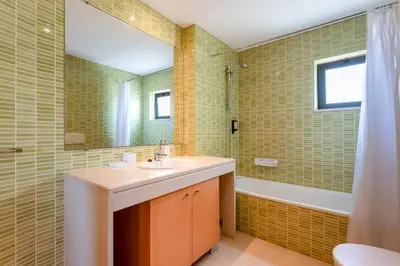 a bathroom with a sink and a mirror and a tub at Penthouse with Pool View in Albufeira by Lovelystay in Albufeira