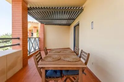a dining room with a table and chairs on a balcony at Penthouse with Pool View in Albufeira by Lovelystay in Albufeira