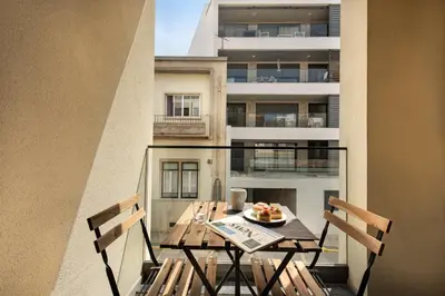 a table and chairs on a balcony with a building at Stay Apartment in Faro