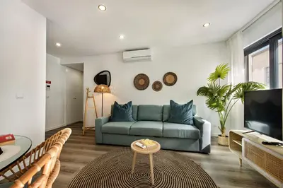a living room with a blue couch and a tv at Stay Apartment in Faro