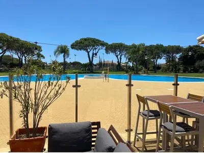 a patio with a table and chairs and a pool at Modern apartment in Al-sakia Village in Quarteira