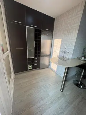 a kitchen with black cabinets and a table at Modern apartment in Al-sakia Village in Quarteira