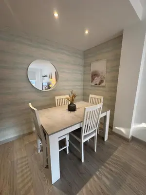 a dining room with a table and chairs and a mirror at Modern apartment in Al-sakia Village in Quarteira