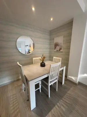 a dining room with a table and chairs and a mirror at Modern Apartament in Al-sakia Village in Quarteira