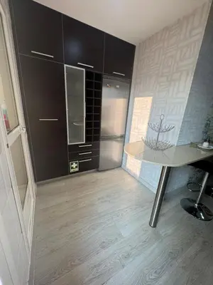 a kitchen with black cabinets and a table at Modern Apartament in Al-sakia Village in Quarteira