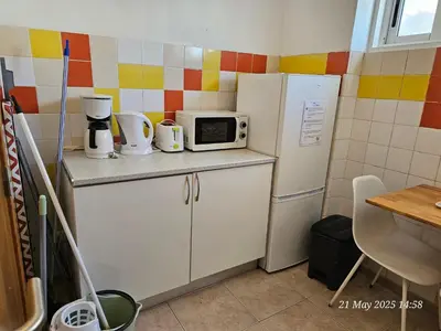 a small kitchen with a refrigerator and a microwave at Blife Cerya private rooms at Faro beach in Faro