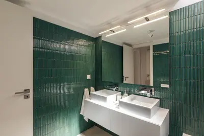 a bathroom with two sinks and green tiled walls at Aldeamento Aldeia do Golf V3 in Vilamoura