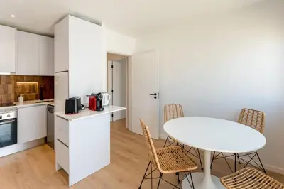 a kitchen with a white table and chairs in a room at Modern 1BDR with Sea View in Albufeira by LovelyStay in Albufeira