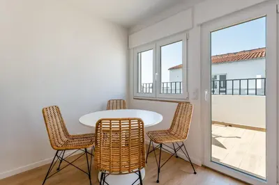 a table and chairs in a room with a balcony at Modern 1BDR with Sea View in Albufeira by LovelyStay in Albufeira