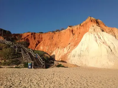 a stairway leading up to a mountain next to a beach at 2 bedroom Apartment Falésia Beach in Albufeira
