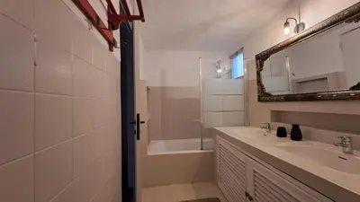 a small room with two beds and a chair at La Balaia - charm and comfort 12 people 9 beds in Albufeira
