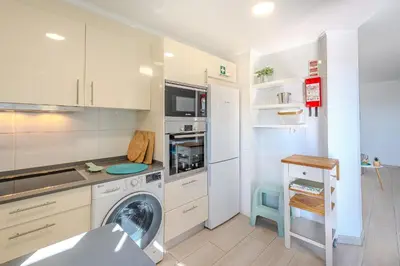 a white kitchen with a washing machine in it at Salgados Sunset and Sea View Apartment in Guia