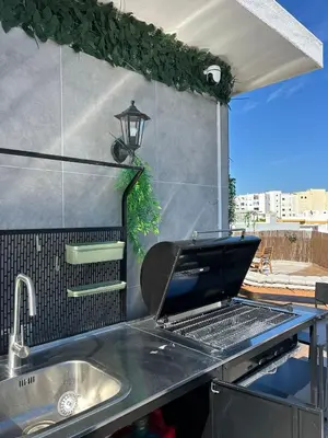 a grill on top of a kitchen with a sink at Beach penthouse paradise T4 in Quarteira