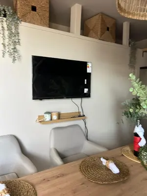 a living room with a table and a tv on a wall at Beach penthouse paradise T4 in Quarteira