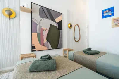 a room with two beds and a painting on the wall at Casa Bella in Faro